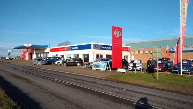 Livingstone Motor Group garage with cars displayed outside, blue sky, and signage for SsangYong and MG.