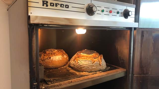 Rustic bread loaves baking in a Rofco oven, with warm light illuminating the crusty tops.