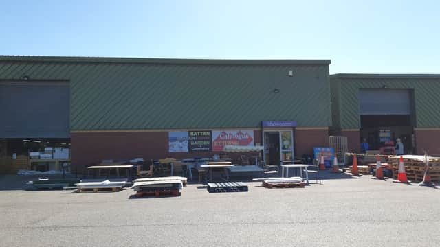 Exterior of Catalogue Returns Ltd in Brotherton, featuring a showroom entrance and pallets outside. Clear blue sky.