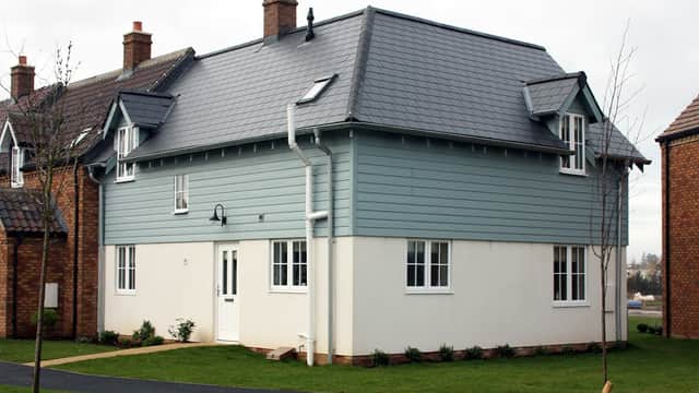 Lovesea Lodge, a two-story house with a blue exterior, white trim, and a well-maintained lawn in Filey, Yorkshire.