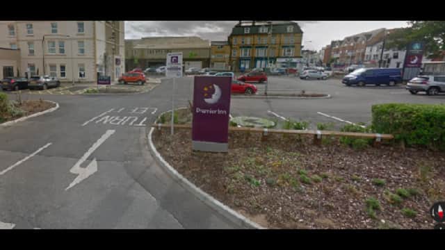 Parking lot with signs for Premier Inn, colorful cars, and landscaped areas in Bridlington, Yorkshire.