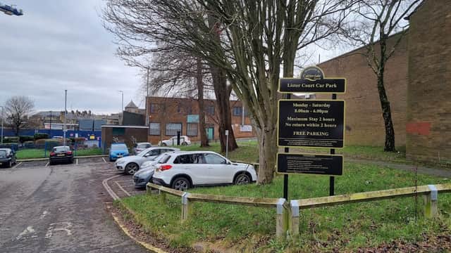 Lister Court Car Park sign with parking spaces, trees, and buildings in Exley, Yorkshire. Free parking available.