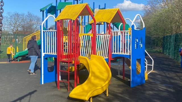 Colorful playground equipment with slides and climbing structures under a clear blue sky in a recreation area.