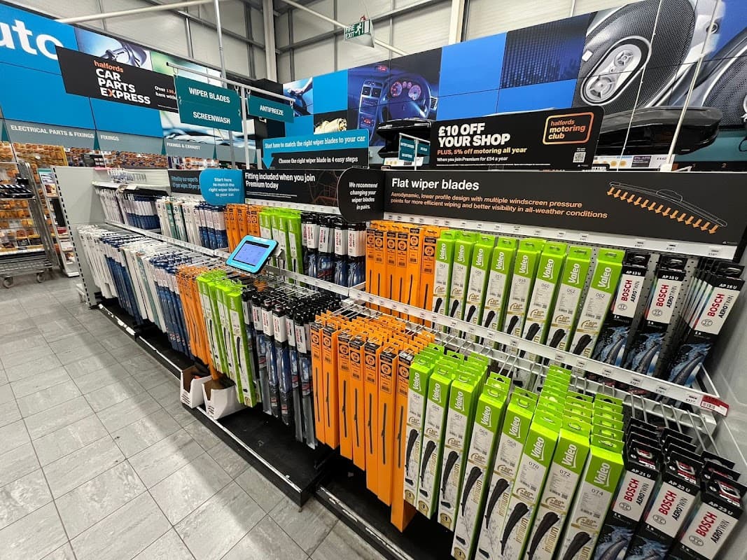 Wiper blades displayed on shelves, with promotional signage and an iPad for customer interaction in a bike shop.