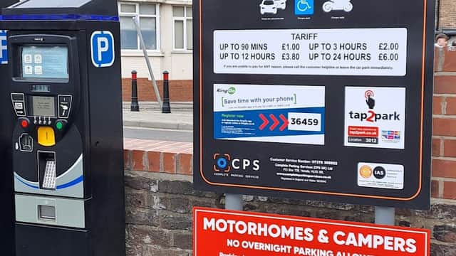 Signage for Dean Road Public Car Park with parking machine and information on tariffs and restrictions.
