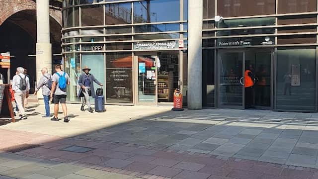 Granary Express Off License storefront with large windows, people walking by, and modern brick architecture in Leeds.