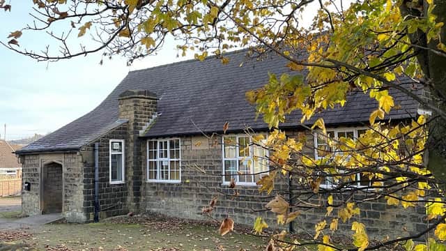Stone building with a sloped roof surrounded by autumn leaves and a low stone wall in Millhouse Green, Yorkshire.