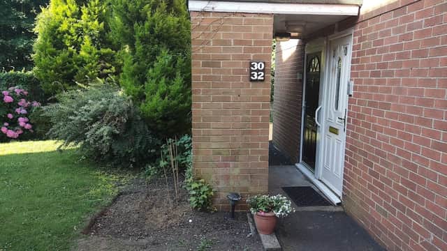 Brick entrance with house numbers 30 and 32, surrounded by greenery and flowering plants in Follifoot, Yorkshire.