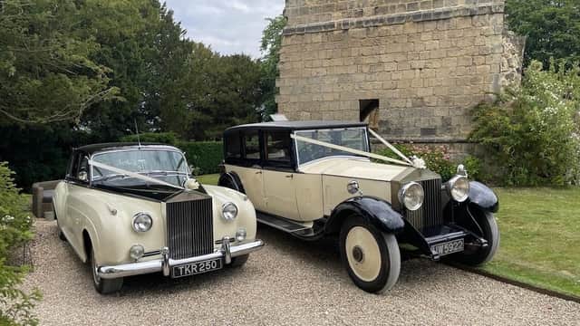 Two classic wedding cars parked near a stone building, surrounded by greenery in Tockwith, Yorkshire.