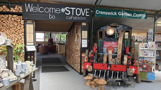 Welcome sign for #Stove Cafebistro, featuring a vintage train display and a cozy seating area with wooden decor.