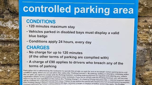 Blue sign detailing parking regulations, maximum stay of 120 minutes, and charges for violations in Lidl Car Park.