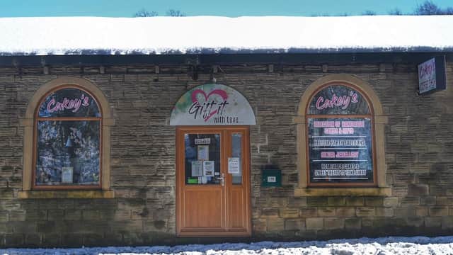 Cakey’s shop in Scissett, Yorkshire, featuring a snow-covered entrance and large windows with colorful signage.