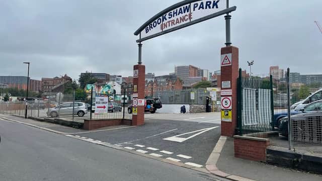 Entrance to Brookshaw Park Car Park with signage, barriers, and surrounding buildings in Sheffield, Yorkshire.