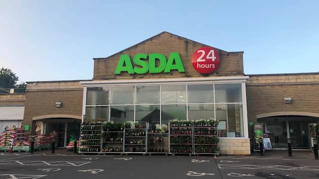 ASDA superstore entrance with large green signage, 24-hour indicator, and plant displays outside.