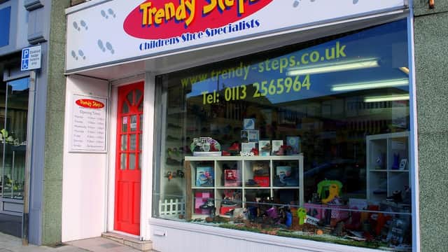 Bright storefront of Trendy Steps shoe shop, featuring children's shoes and colorful displays, with a red door and signage.