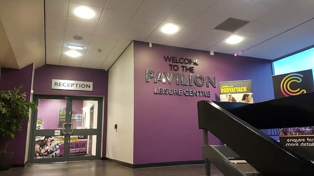 Reception area of Thornaby Pavilion with purple walls, signage, and a staircase leading to upper levels.
