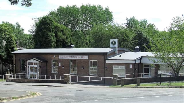Catcliffe Memorial Hall, a modern brick building with large windows, surrounded by trees and a clear blue sky.