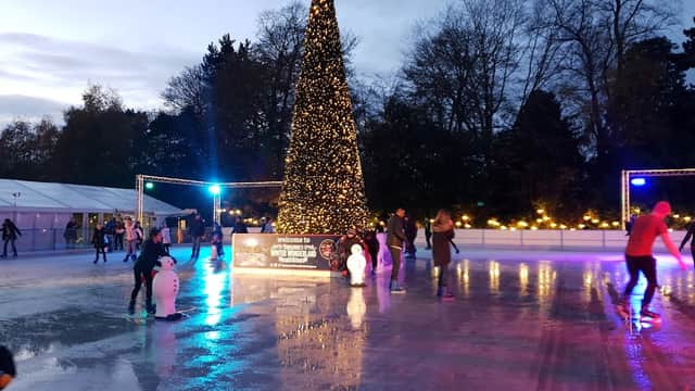 Skaters on an ice rink surrounded by twinkling lights and a large Christmas tree in Yorkshire's Winter Wonderland.