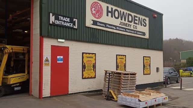 Howdens Joinery Co. building exterior with a trade entrance, signage, and pallets outside in Farsley, Yorkshire.