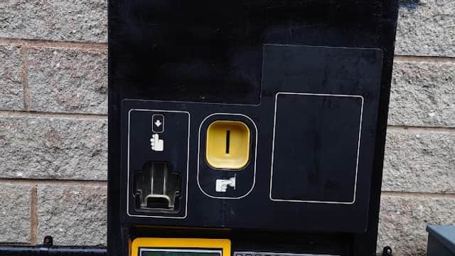 Pay & Display parking machine with instructions, coin slot, and keypad, set against a stone wall in Slaithwaite Mills Carpark.