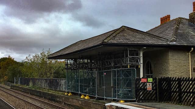 Mytholmroyd Station car park with scaffolding, railway tracks, and cloudy sky in Chiserley, Yorkshire.