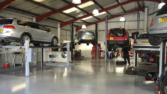 Northowram Garage interior with cars on lifts, tools, and service equipment in a well-lit workshop.