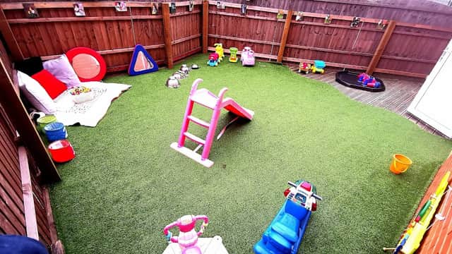 Colorful play area with artificial grass, toys, slides, and climbing equipment for young children at Once Upon a Time Nursery.