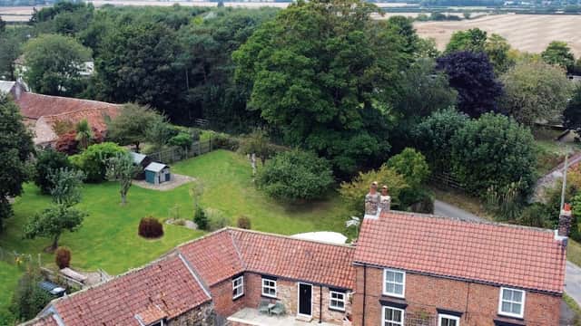 Aerial view of West End Farmhouse with gardens, trees, and fields in the background, set in a rural Yorkshire landscape.