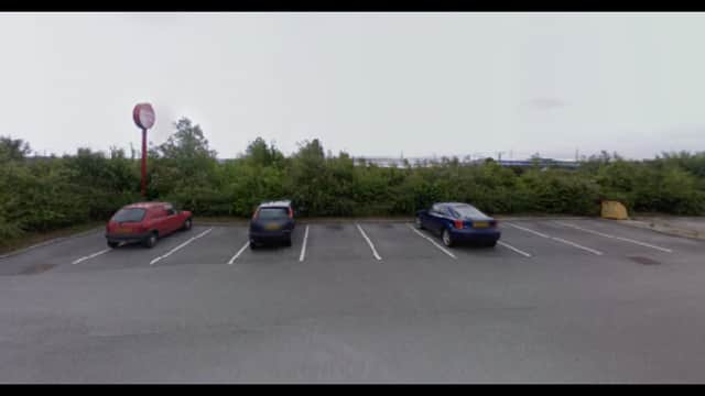 Pay & Display parking area in Birstall, Yorkshire, with three parked cars and overgrown greenery in the background.