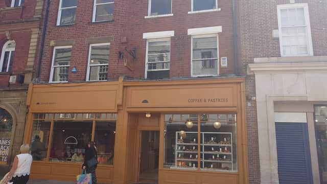 The Cornish Bakery storefront features a warm orange facade, large windows, and displays of pastries inside.