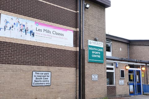 Exterior view of East Riding Leisure South Cave, featuring a sign for Les Mills classes and a reserved parking notice.