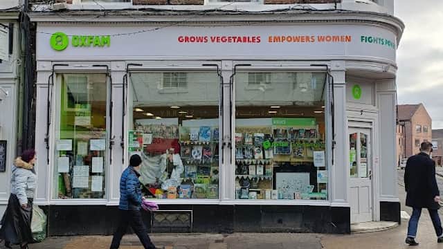 Oxfam bookshop exterior in Harrogate, featuring a large window display and signage promoting social causes.