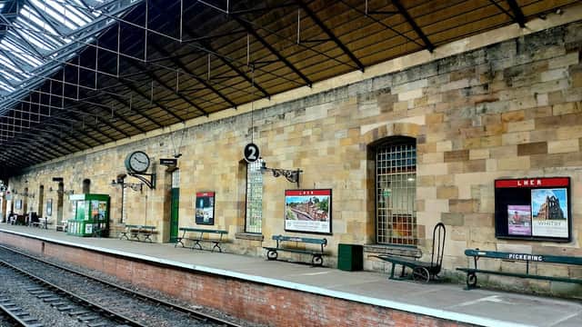 Historic stone platform with benches, vintage posters, and a clock at Pickering Station Tea Room in Yorkshire.