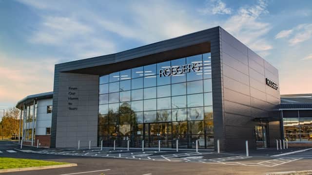 Modern storefront of Rodgers Of York Ltd, featuring large glass windows and a sleek design against a clear sky.