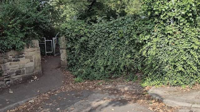 Entrance to the Wilton Park Greenway, surrounded by lush greenery and a directional sign indicating the path.