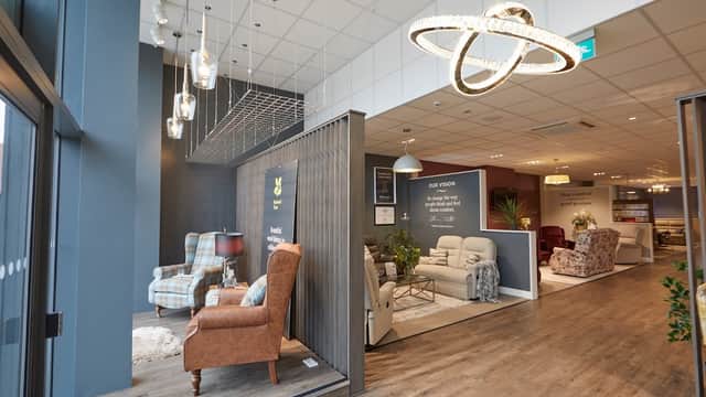 Stylish furniture display with armchairs, sofas, and modern lighting in a spacious showroom.
