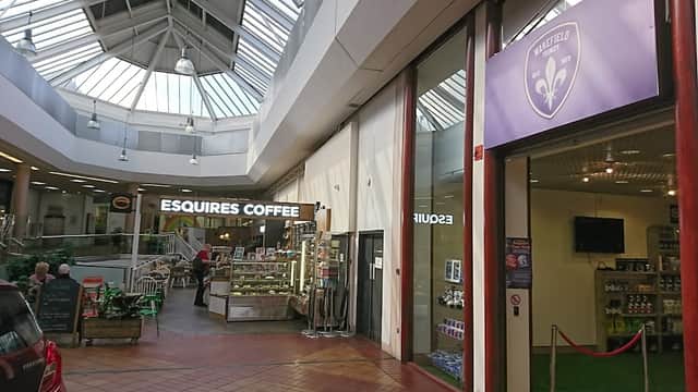 Bright atrium with skylights, featuring Esquires Coffee and a car wash entrance in The Ridings Shopping Centre.