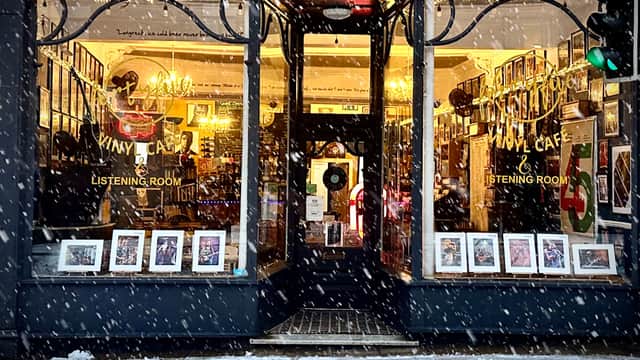 Vinyl café storefront with large windows, plants, and a sign announcing "NOW OPEN" in York, Yorkshire.