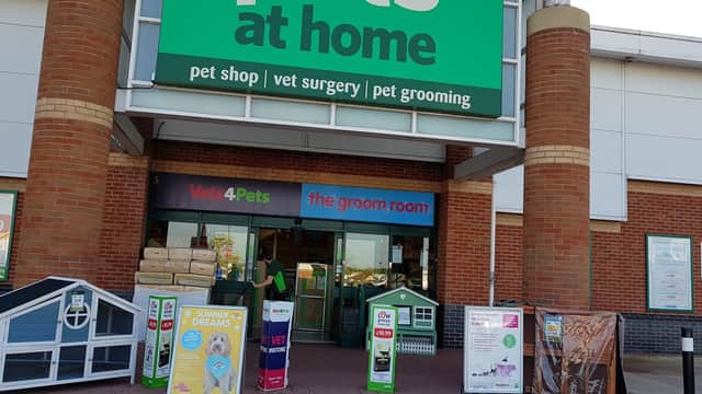 Bright storefront of Pets at Home, featuring signs for pet shop, vet surgery, and grooming services, with promotional displays.