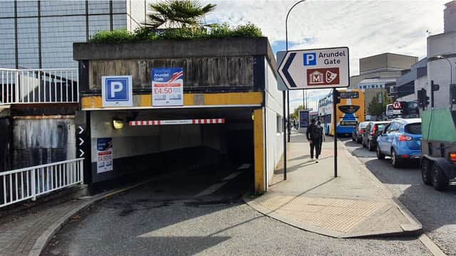 Entrance to Arundel Gate Car Park with signage, vehicles, and pedestrians along a busy street in Sheffield.
