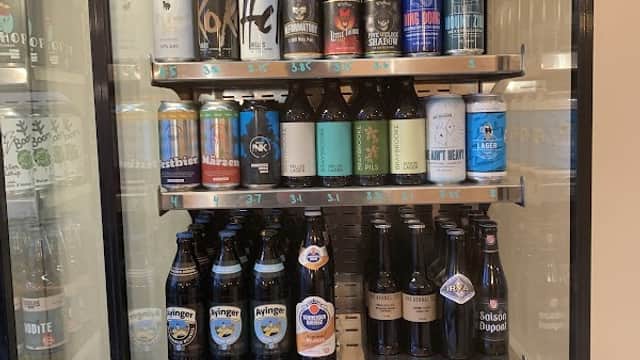 Refrigerated display filled with various craft beer cans and bottles, showcasing a diverse selection of brews.