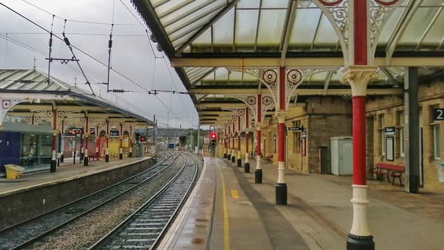 Victorian-style platform with ornate supports, railway tracks, and a cloudy sky at Skipton Railway Station.