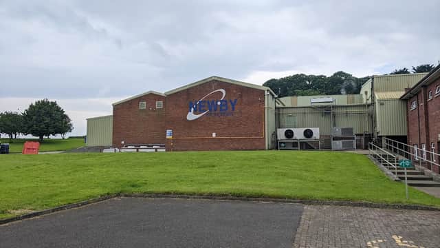 Newby Foods building with a large sign, grassy area, and parking lot in Newby Wiske, Yorkshire.