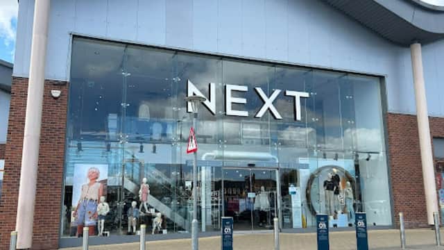 Large glass storefront of Next shop with mannequins displaying clothing, located in Catterick Garrison, Yorkshire.