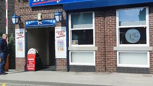 Exterior of Locky’s Bar featuring a blue sign, brick facade, and entrance with a red sign, set in Wombwell, Yorkshire.