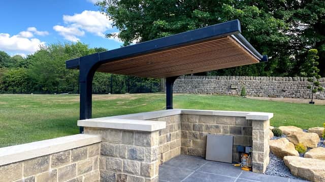 Pay & Display parking area with a modern shelter, stone walls, and a landscaped green space in West Tanfield, Yorkshire.