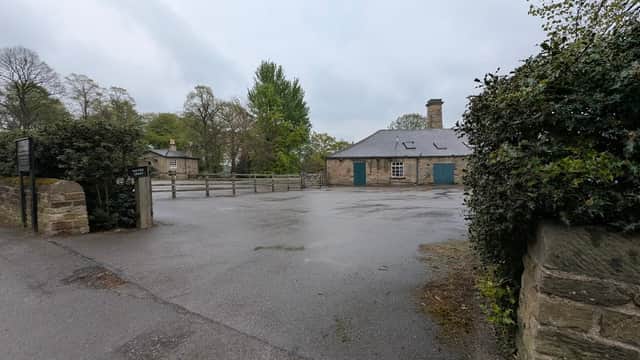 Pay & Display car park with a stone building, trees, and a gravel path in Wentworth, Yorkshire.
