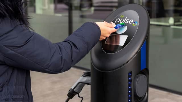 A person using a contactless card at a bp pulse electric vehicle charging station in Acomb, Yorkshire.