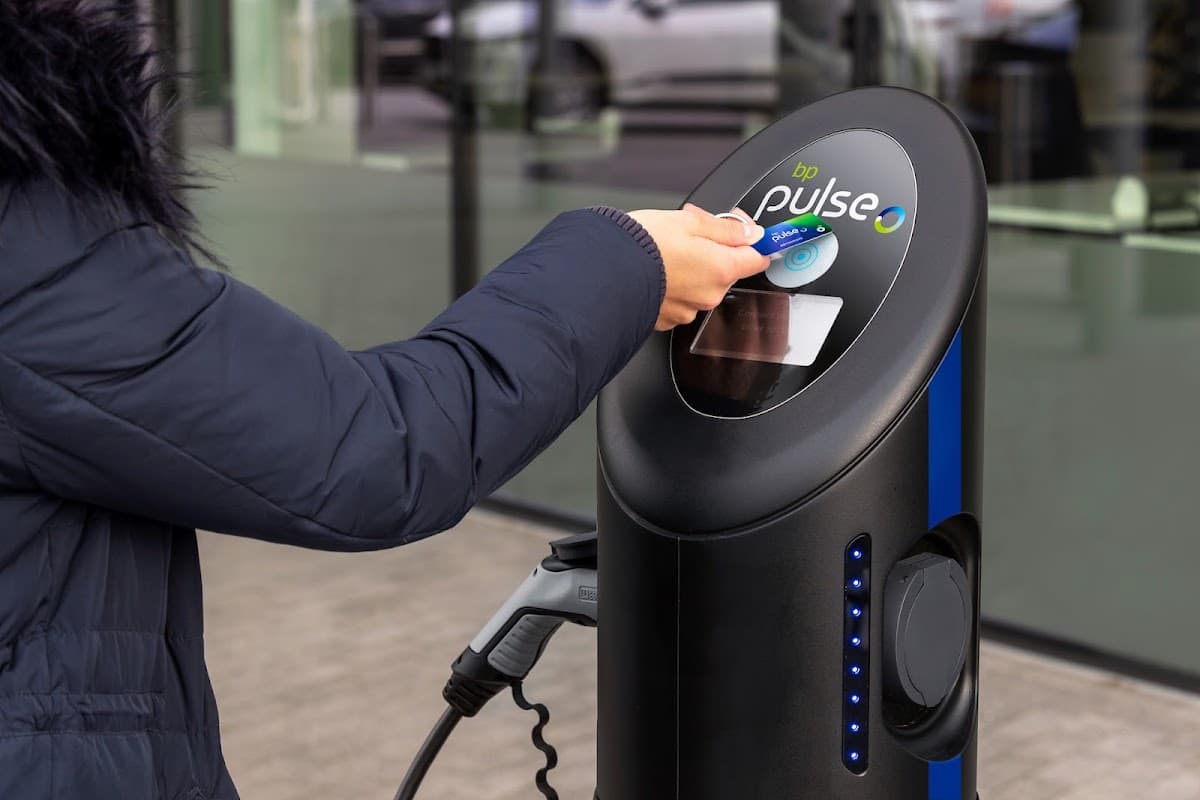A person using a contactless card at a bp pulse electric vehicle charging station in Acomb, Yorkshire.