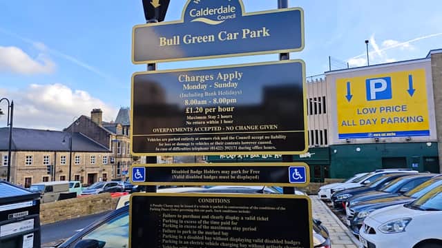 Welcome sign for Bull Green Car Park in Exley, Yorkshire, with parking charges and conditions displayed. Cars parked nearby.